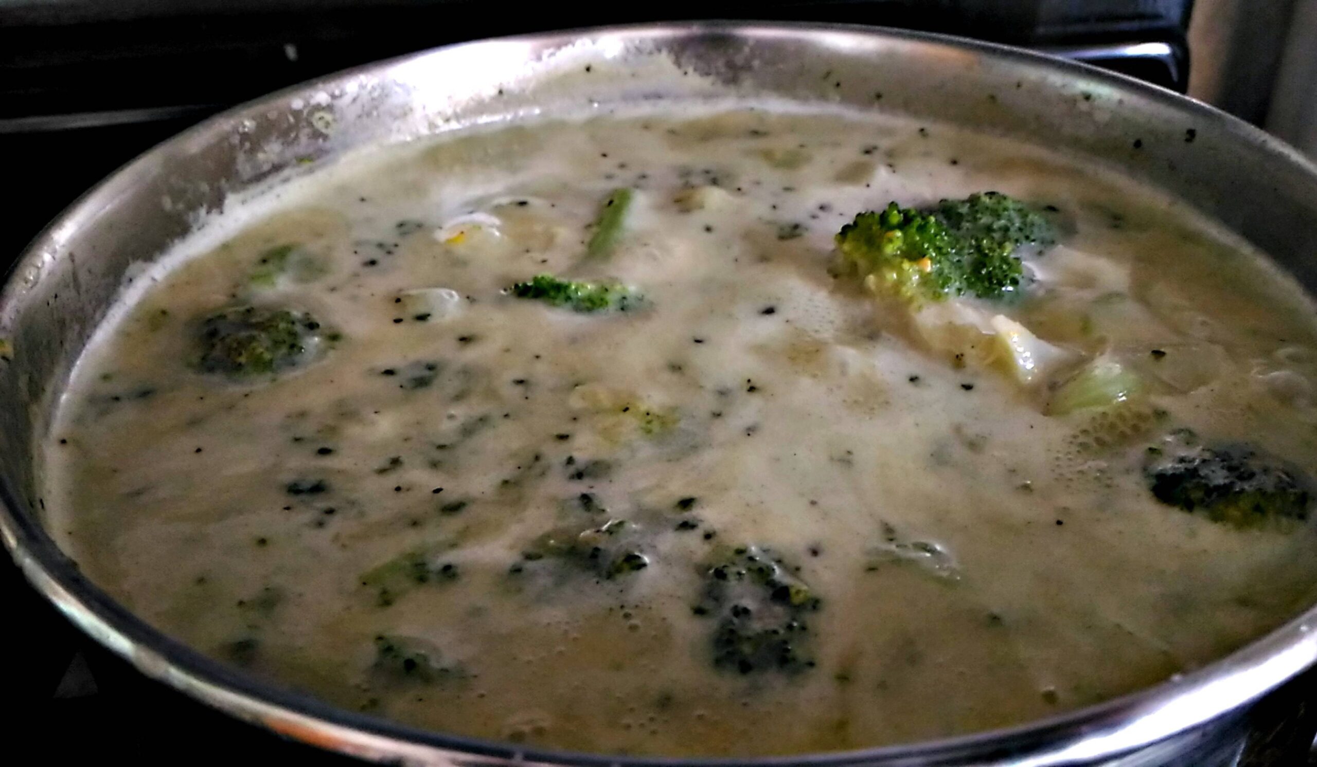 Creamy Pumpkin and Cauliflower Soup served in a rustic bowl, garnished with fresh herbs and a drizzle of coconut milk, showcasing a smooth, vibrant orange texture.